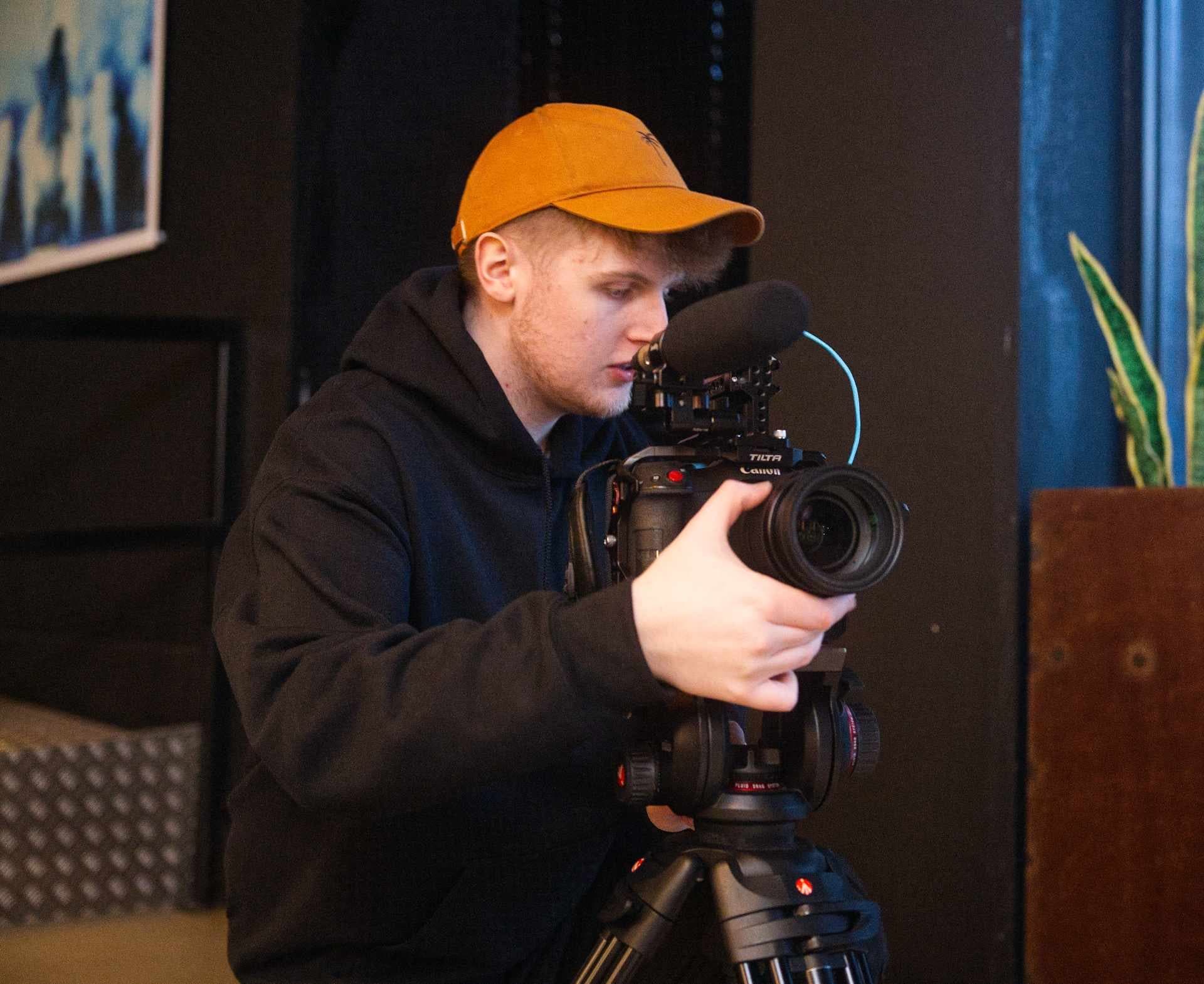 Crew member adjusting camera for education video production